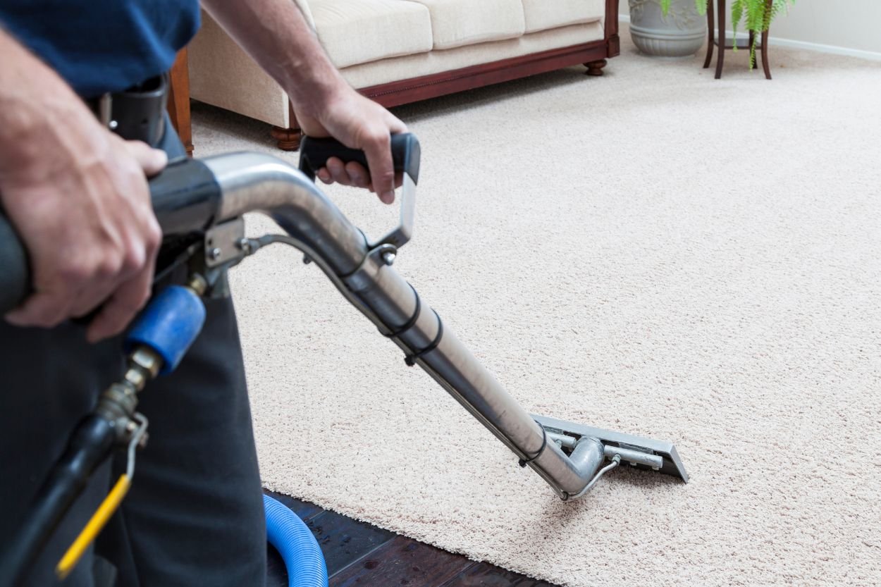 A man operates a vacuum on a carpet, highlighting a mold removal service in Las Vegas, NV.