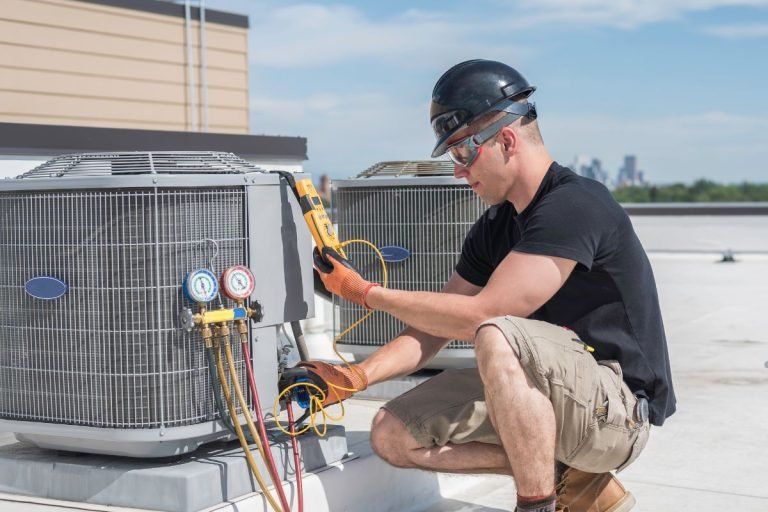 A technician servicing an air conditioning unit, utilizing UV lights for enhanced HVAC efficiency and air quality.