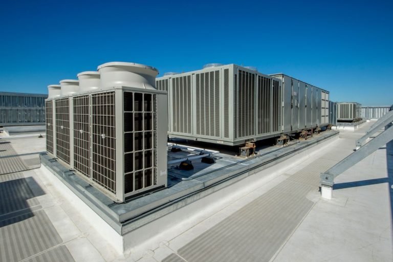 Rooftop view of multiple air conditioning systems installed on a flat surface, showcasing their arrangement and size.
